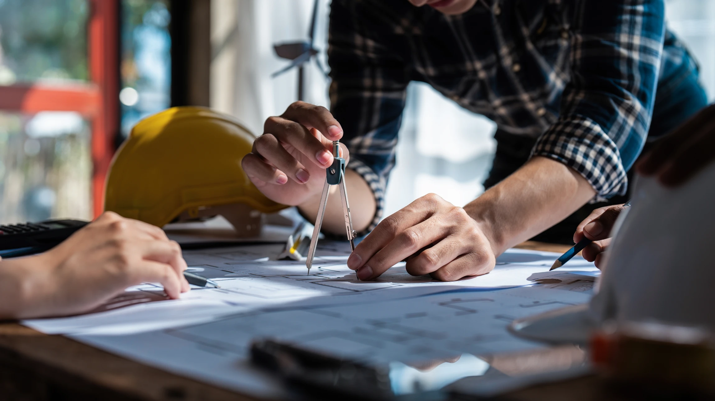 Architecte ou ingénieur travaillant sur plans techniques dans bureau lumineux